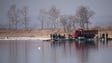 People and a truck embark a boat on the Yalu River