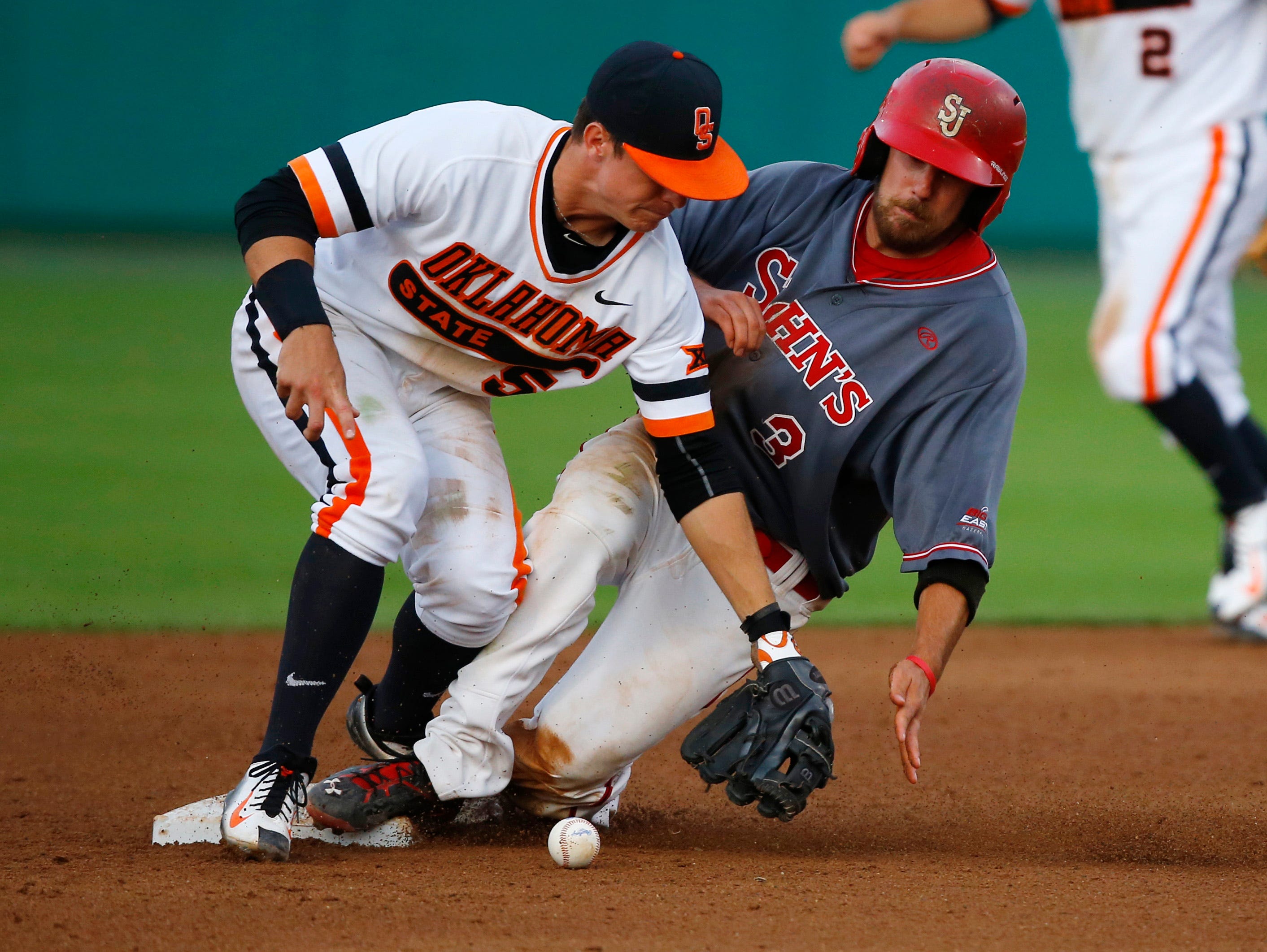 Robert Wayman (3) of St. John's slides safely into second base as Oklahoma State shortstop Donnie Walton (5) takes the throw during their regional game in Stillwater, Okla., on Sunday.