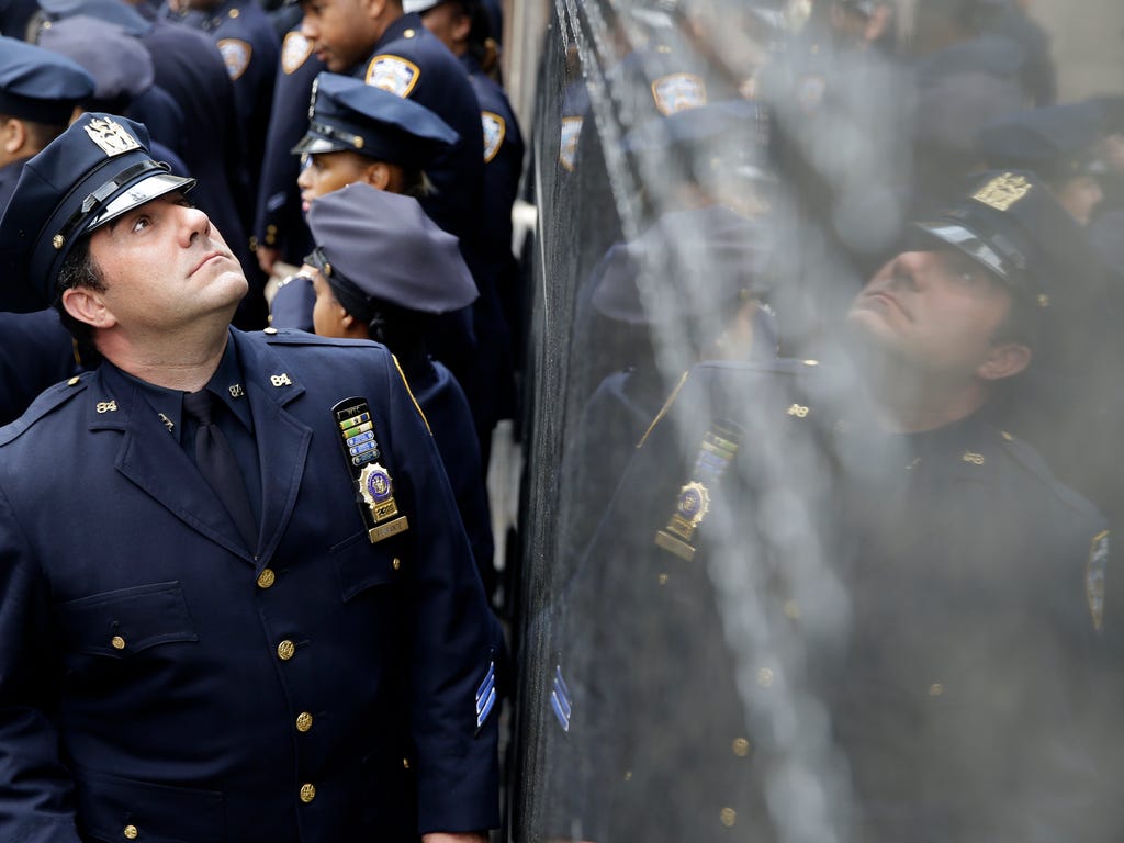 A police officer looks at the names of officers who died in the line of duty during a rededication ceremony at the Police Memorial Wall in Battery Park. The New York Police Department holds a ceremony every year to honor officers who died in the line