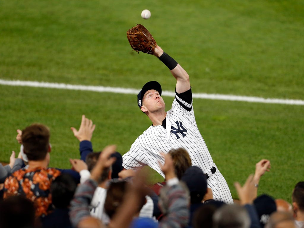 New York Yankees third baseman Todd Frazier catches a foul ball against the Minnesota Twins during the first inning in the 2017 American League wildcard playoff baseball game at Yankee Stadium in New York.