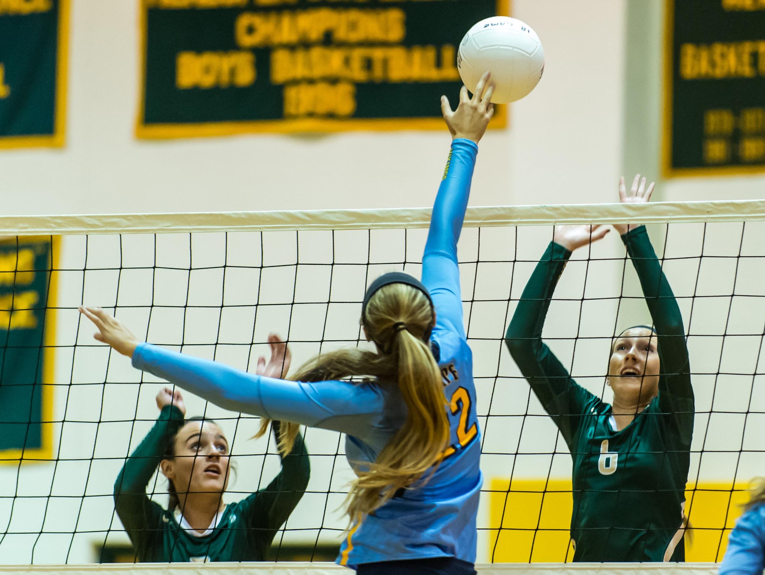 Cape Henlopen's Cameron Wick (22) slips a spike through Indian River's Carly Collins (7) and Julia Bomhardt (6) on Tuesday evening at Indian River.