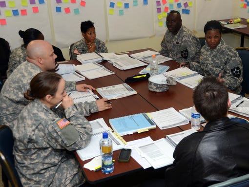 Army soldiers and a civilian have a group discussion