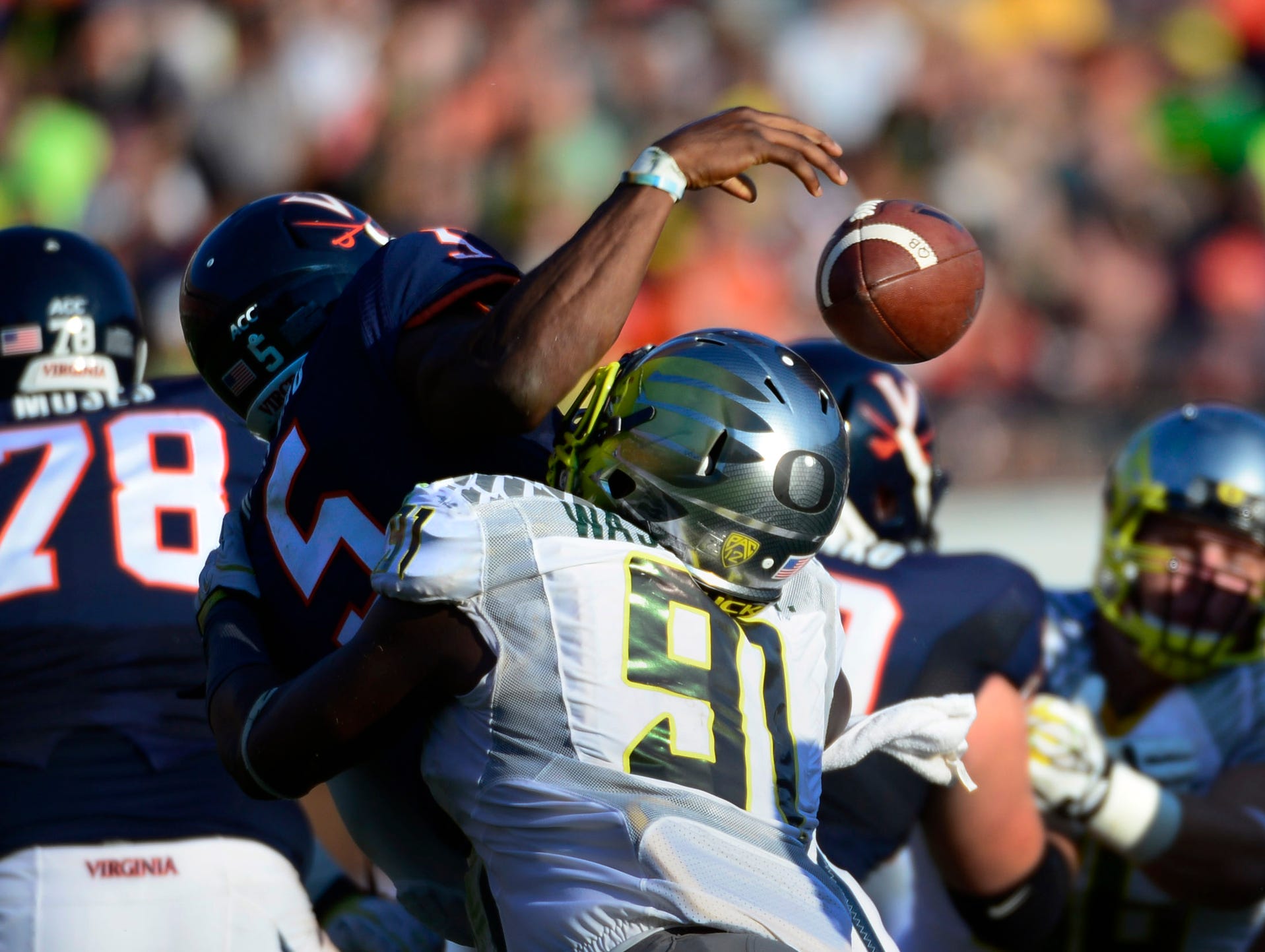 Oregon Ducks defensive end Tony Washington forces Virginia quarterback David Watford to fumble.