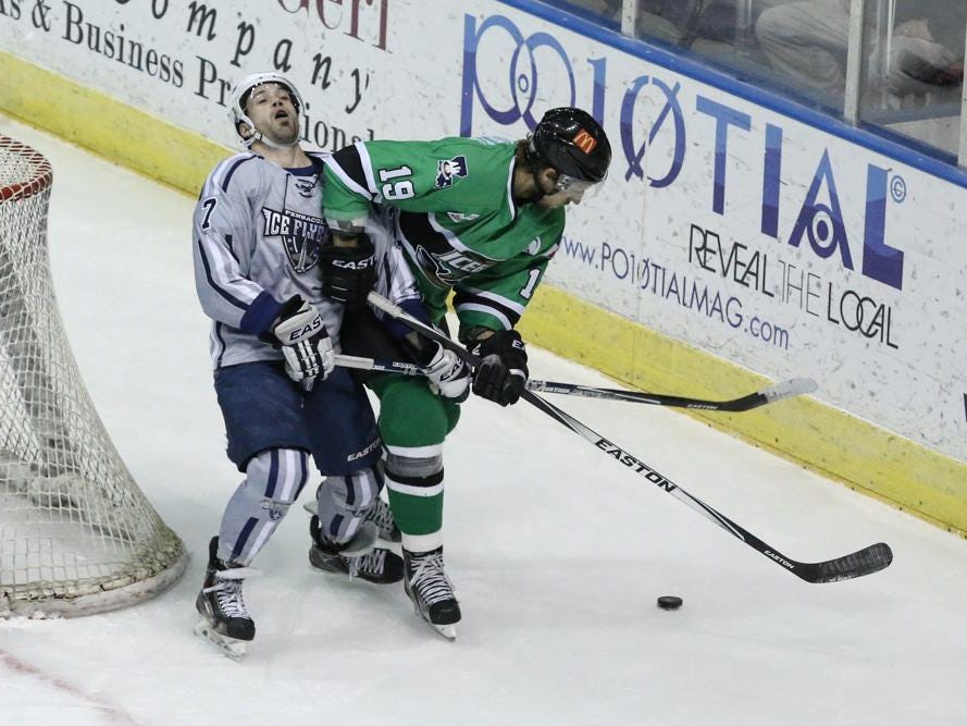 Josh Cousineau, left, of the Ice Flyers, falls back after getting hit with an elbow from Jake Hauswirth during Friday night's game at the Pensacola Bay Center.