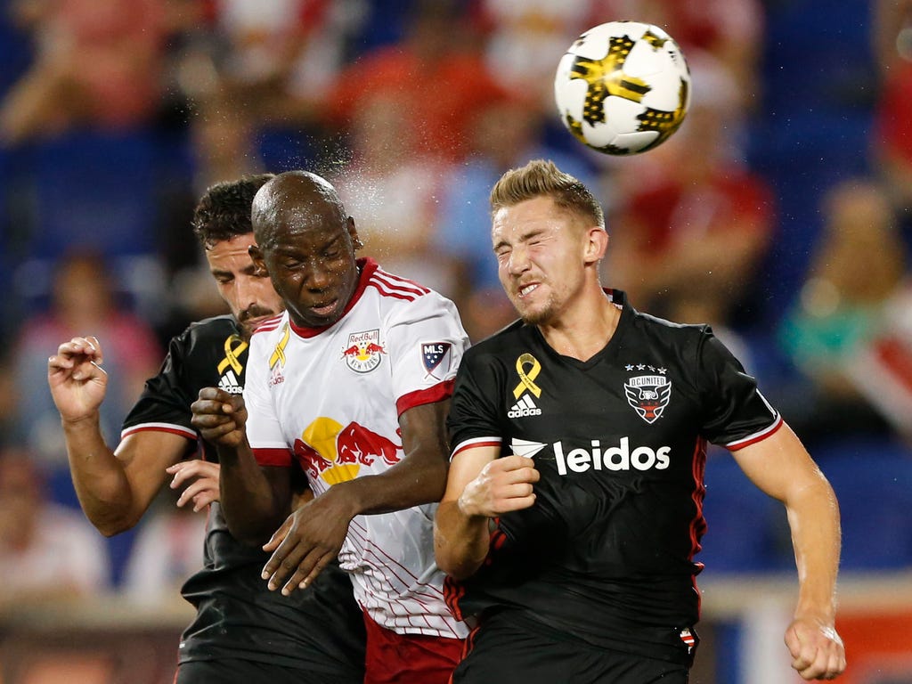 D.C. United midfielder Russell Canouse, right, heads the ball away from New York Red Bulls forward Bradley Wright-Phillips during the second half at Red Bull Arena in Harrison, N.J.