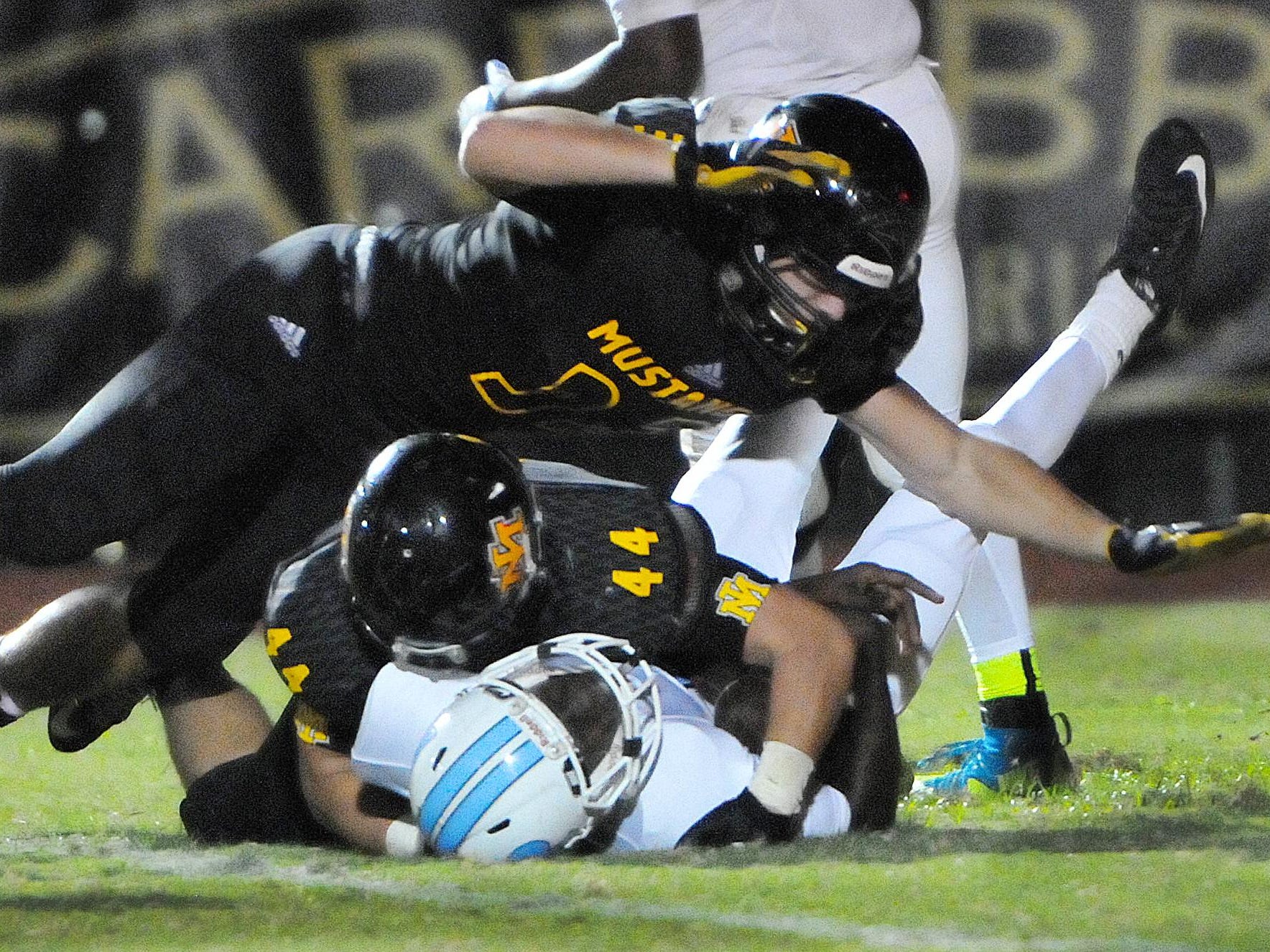 Merritt Island Peter Demorat (44) and Ashlon Wilson (33) sacks Rockledge QB Jaquez Lyons during Friday night’s game at Merritt Island.