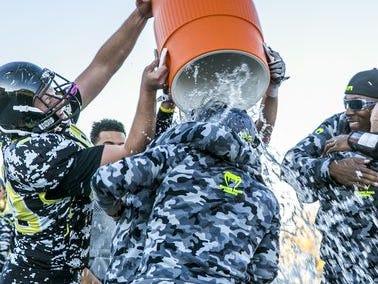 Diamond Ranch players celebrate winning the 1A football title by giving their coaches a nice cold bath.