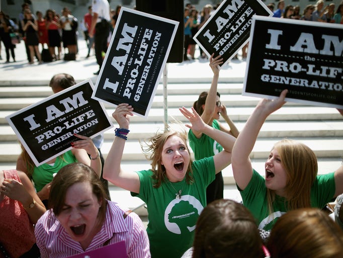 Demonstrators react June 30 after the Supreme Court ruled that closely held corporations can use religious objections to opt out of federal health requirements. Hobby Lobby had challenged the Affordable Care Act's mandate that employee health plans must provide full contraceptive coverage.