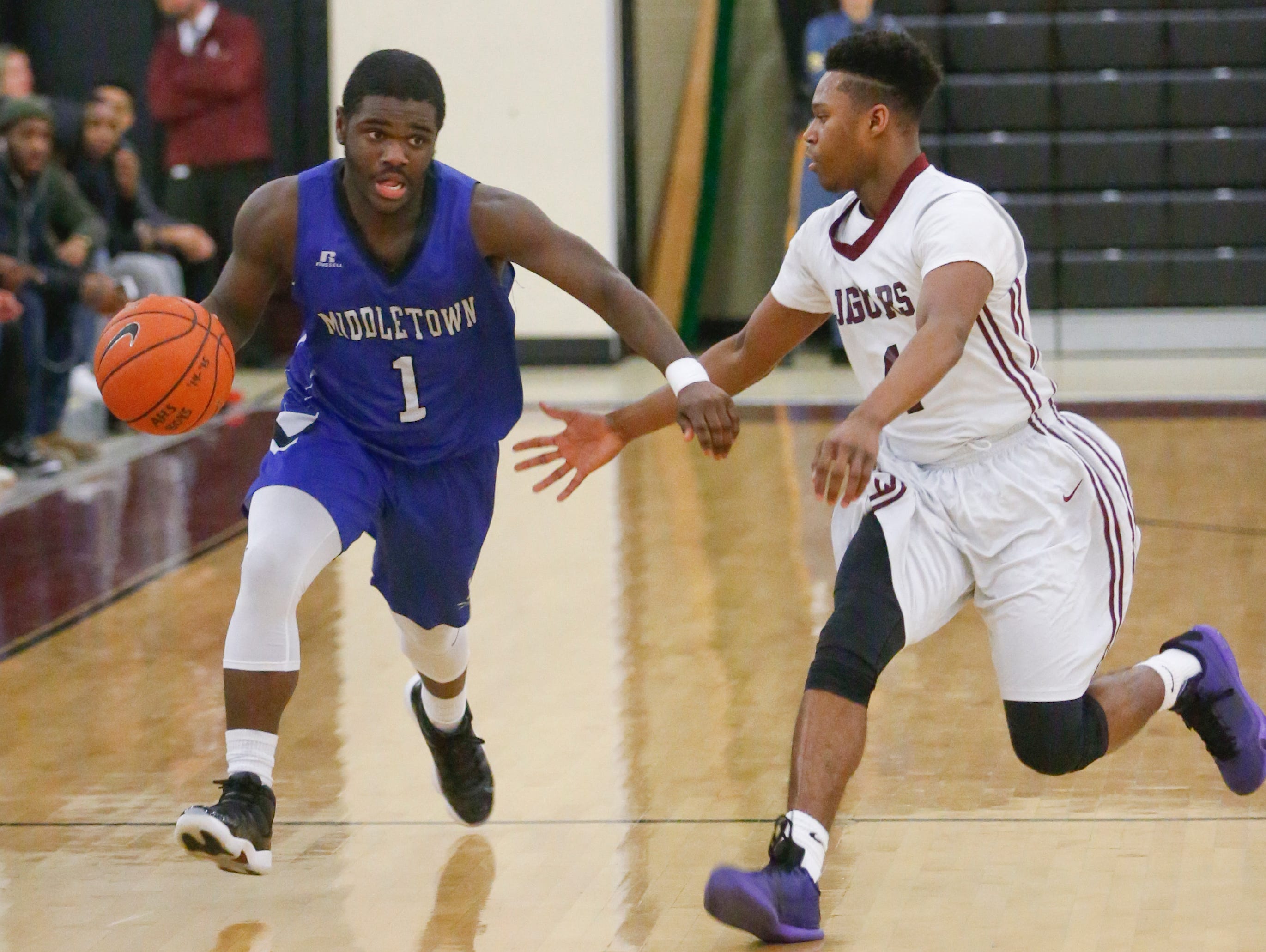 Middletown's Ahmir Glover (1) moves the ball up court against Appoquinimink's Travis Holmes in Appoquinimink's 76-66 win at home Wednesday.