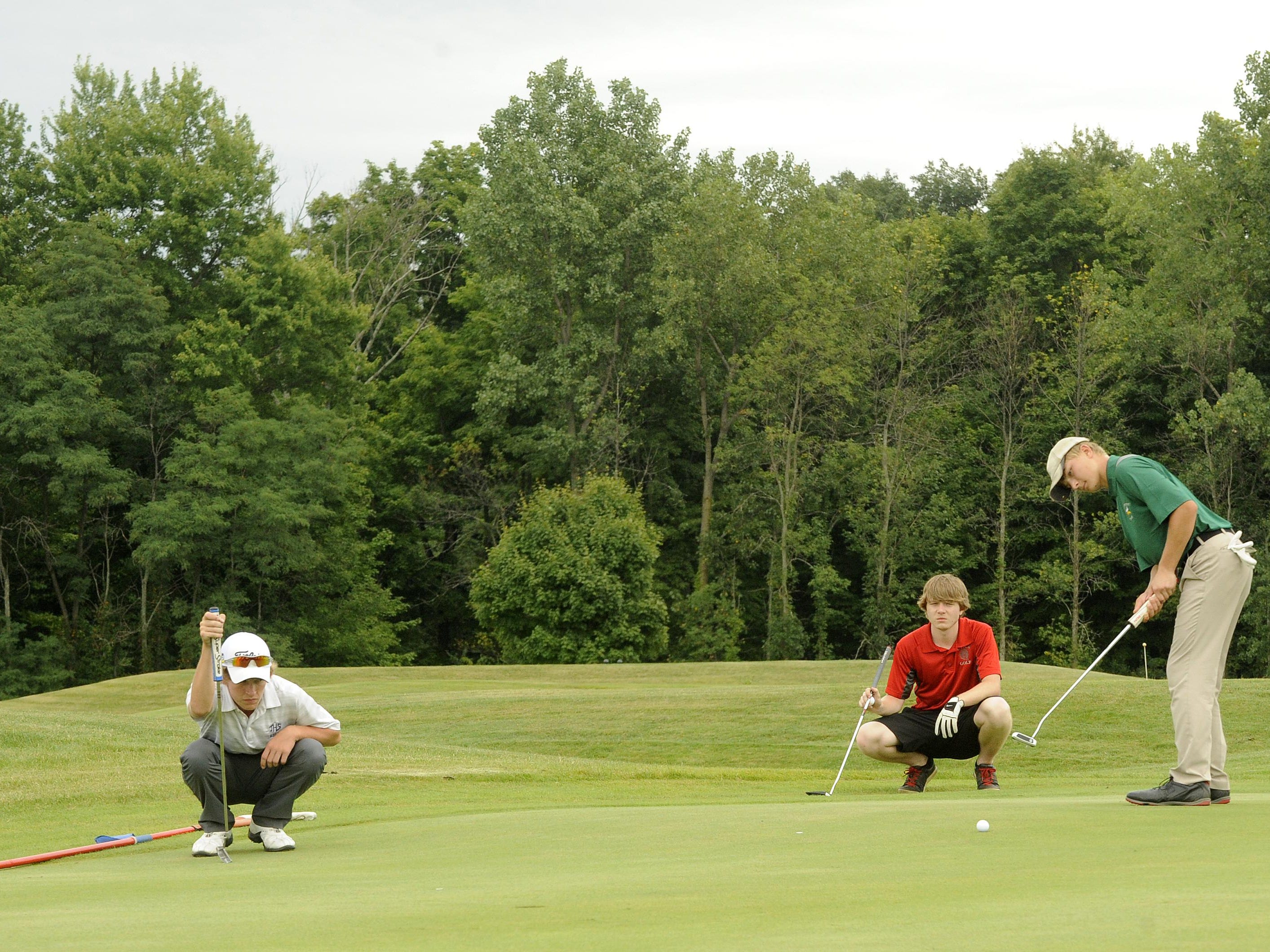 Johnstown’s Jared Williams and Utica’s Tyler Salyer read the green as Northridge’s Jared Teeter putts on No. 18 during the Utica Invitational on Thursday at the Links at Echo Springs.