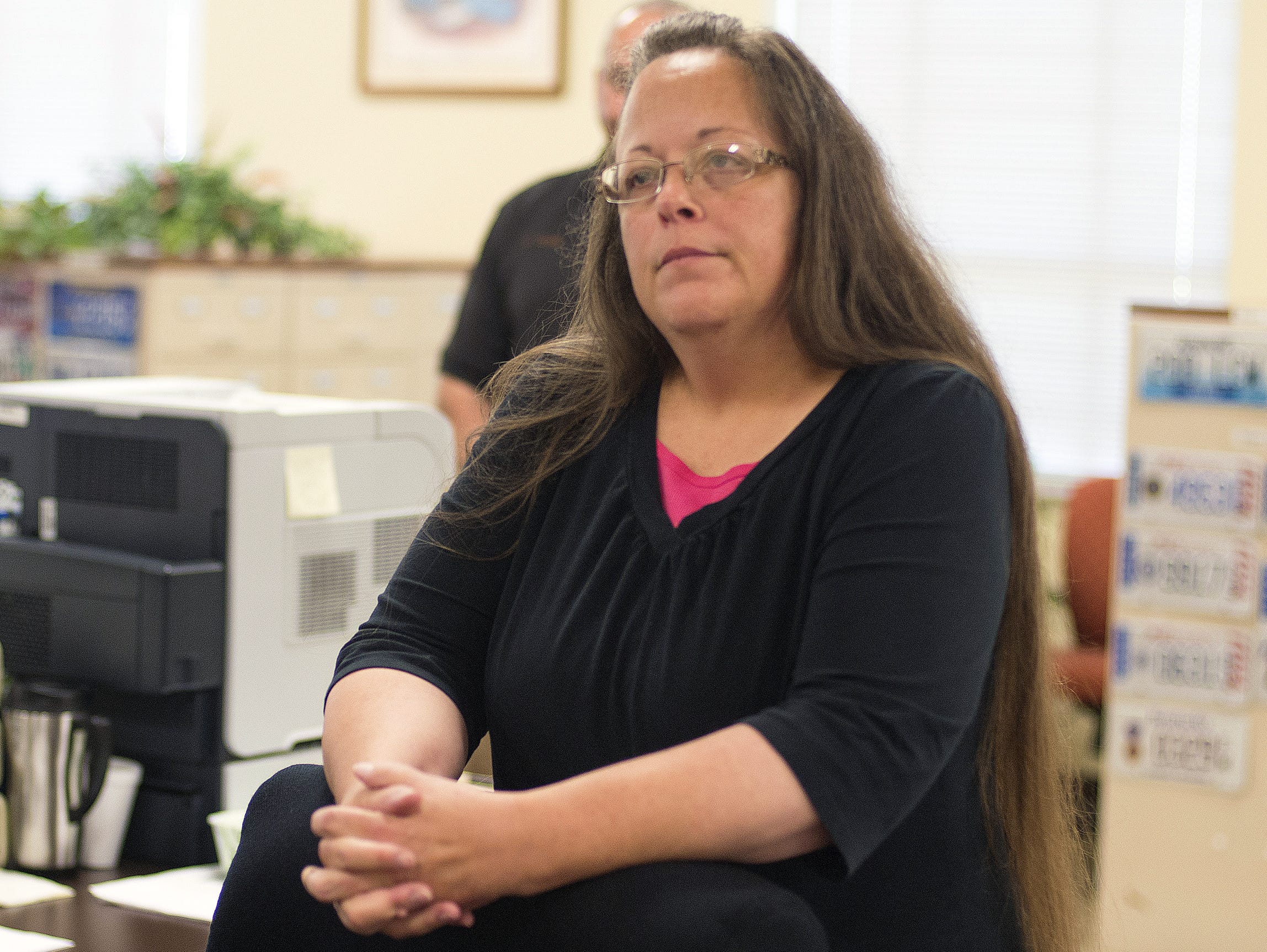Rowan County Clerk Kim Davis listens to Robbie Blankenship and Jesse Cruz as they speak with her Sept. 2, 2015, at the County Clerk's Office in Morehead, Ky.