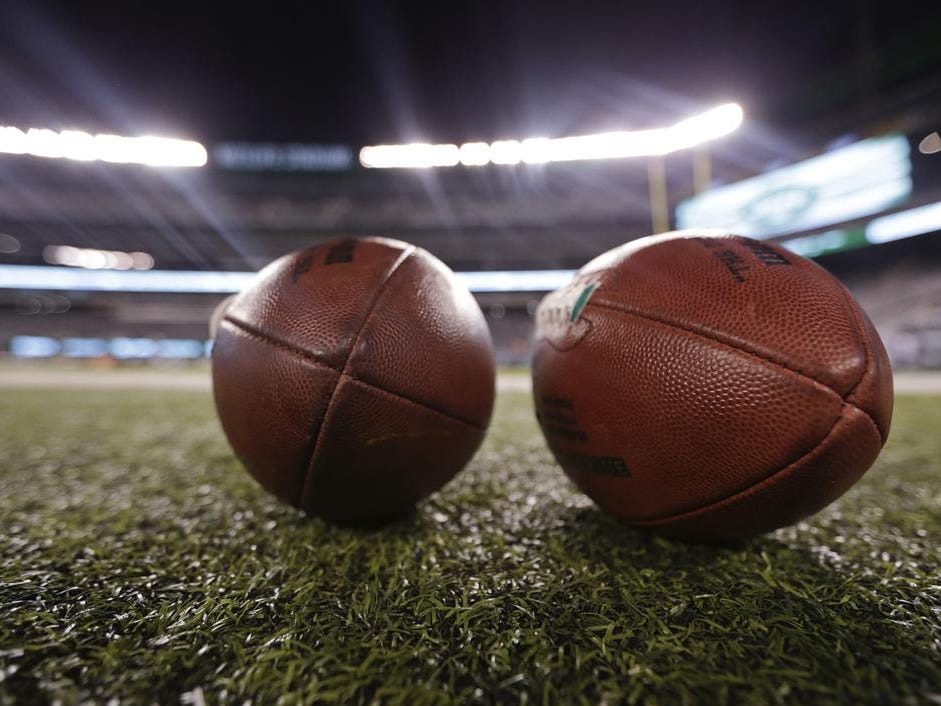 NFL footballs sit on the sidelines before an NFL football game between the New York Jets and the Chicago Bears, Monday, Sept. 22, 2014, in East Rutherford, N.J. (AP Photo/Julio Cortez)