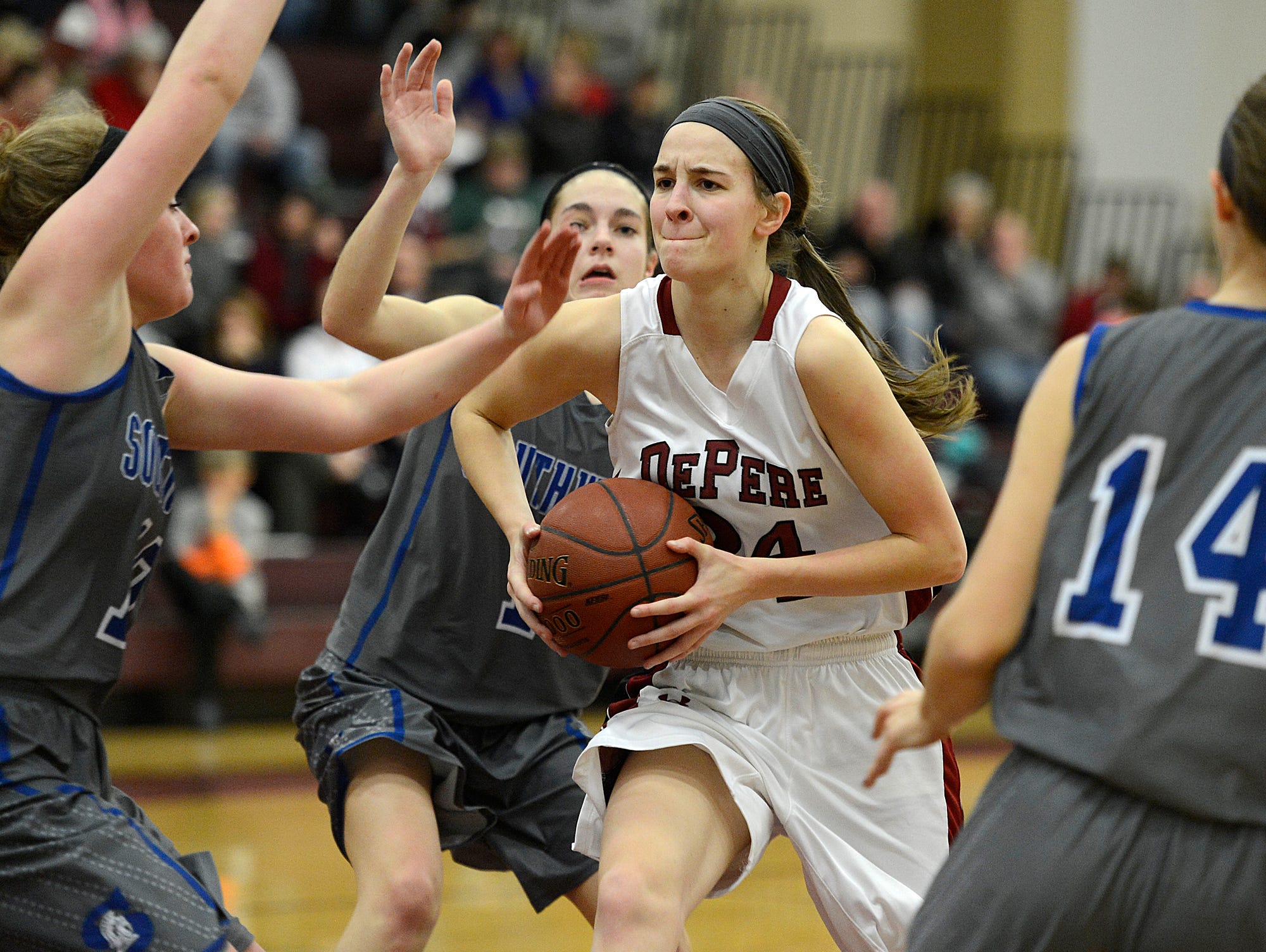 De Pere's Jessie Rabas tries to get by several Green Bay Southwest defenders while driving to the basket in a January game at De Pere High School.