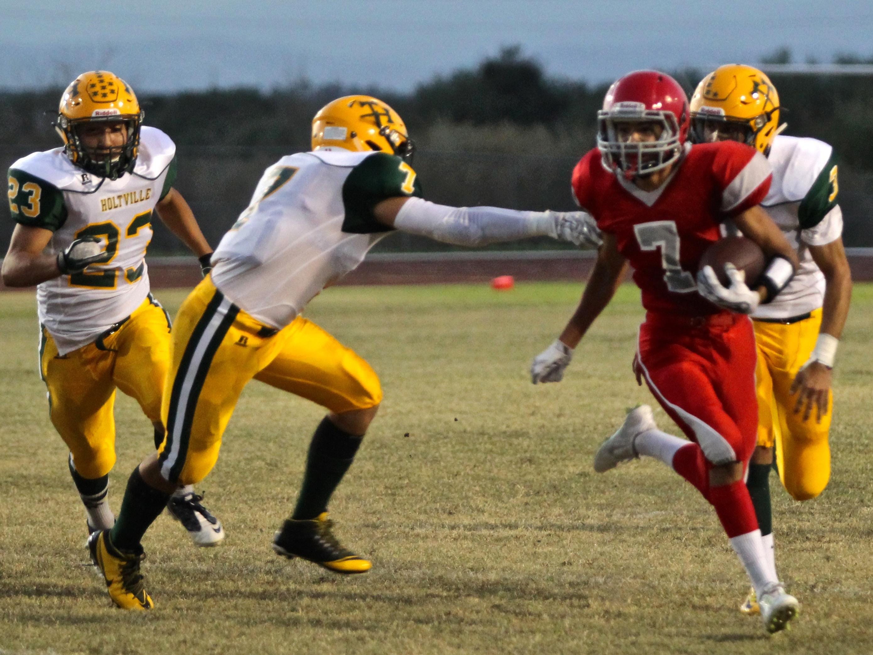 Desert Mirage’s Jesus Ortiz (7) sprints as he attempts to avoid being tackled by Holtville’s Adam Montes (7) in high school football Friday night.