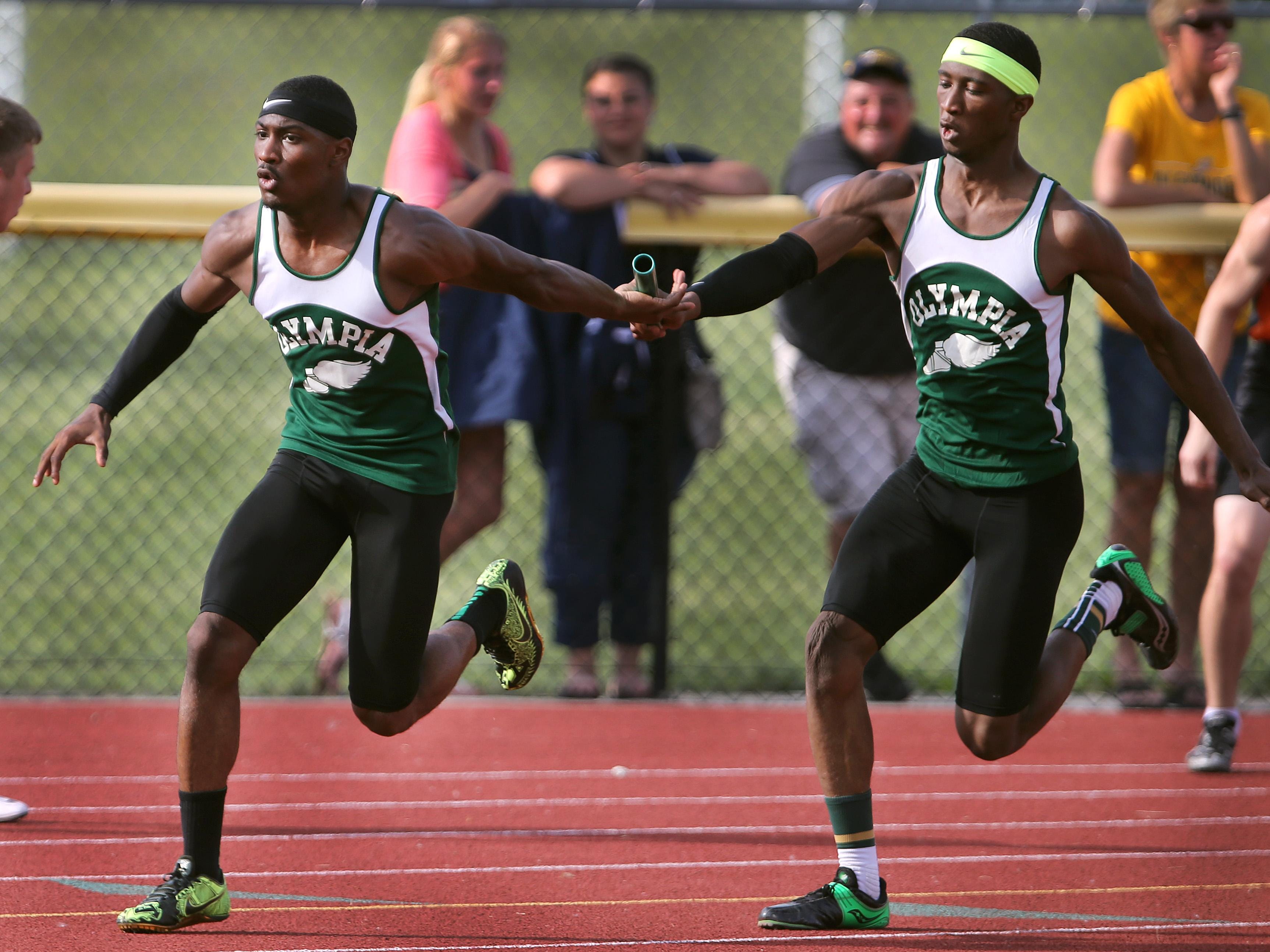Olympia's Tre’Maine Moore, right, hands off the baton to anchor runner Carnell Noble enroute to winning the 4x100 relay at the state qualifier Friday at Caledonia-Mumford High School.