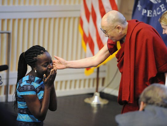 The Dalai Lama reaches out his hand to greet Victoria