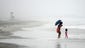 People walk near the water as Hurricane Arthur approaches on July 3 at Wrightsville Beach, N.C.