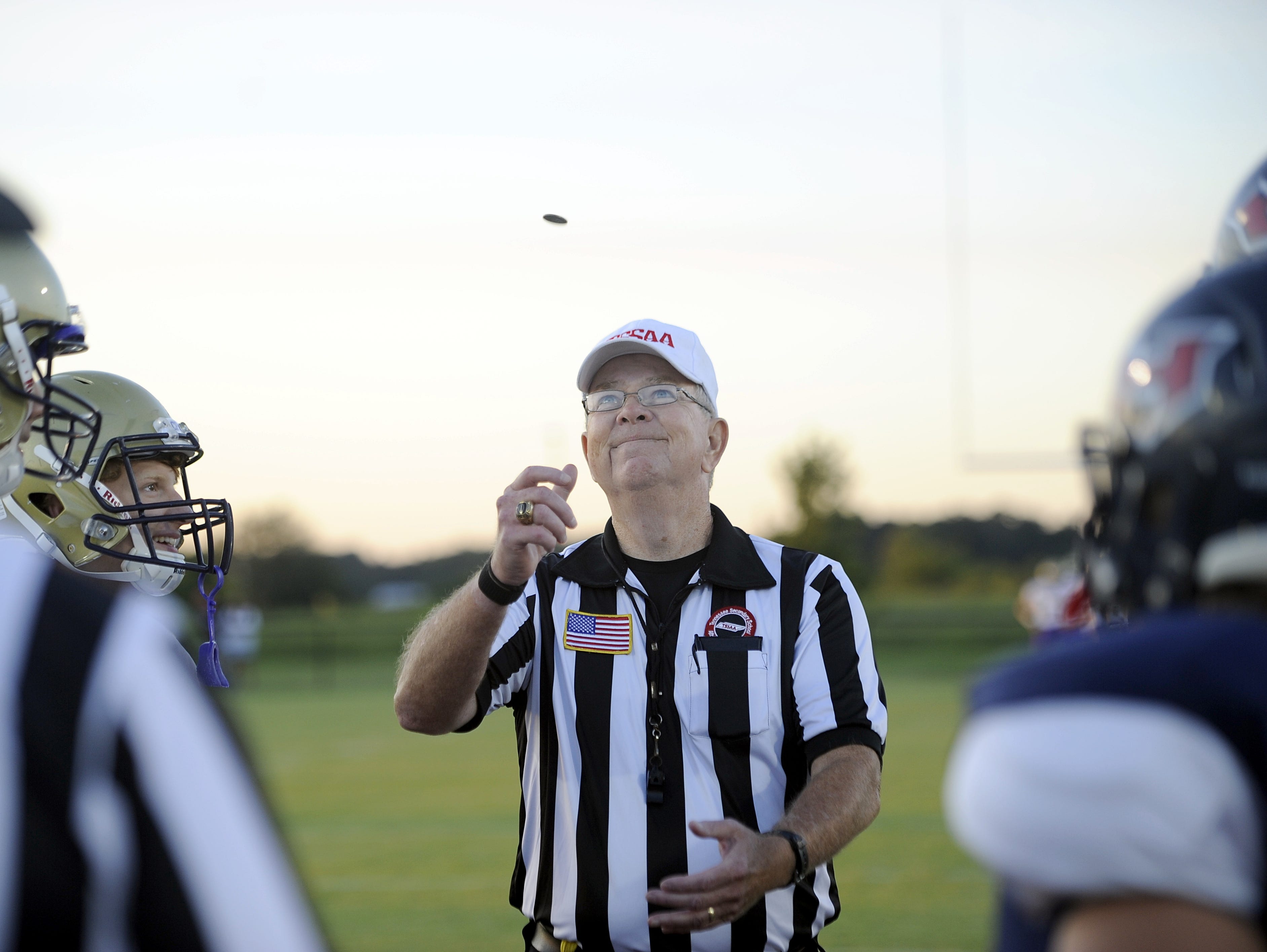 Referee Jody Swearingen of the North Middle Football Officials Association flips the coin prior to a game between Christ Presbyterian Academy and White House-Heritage.