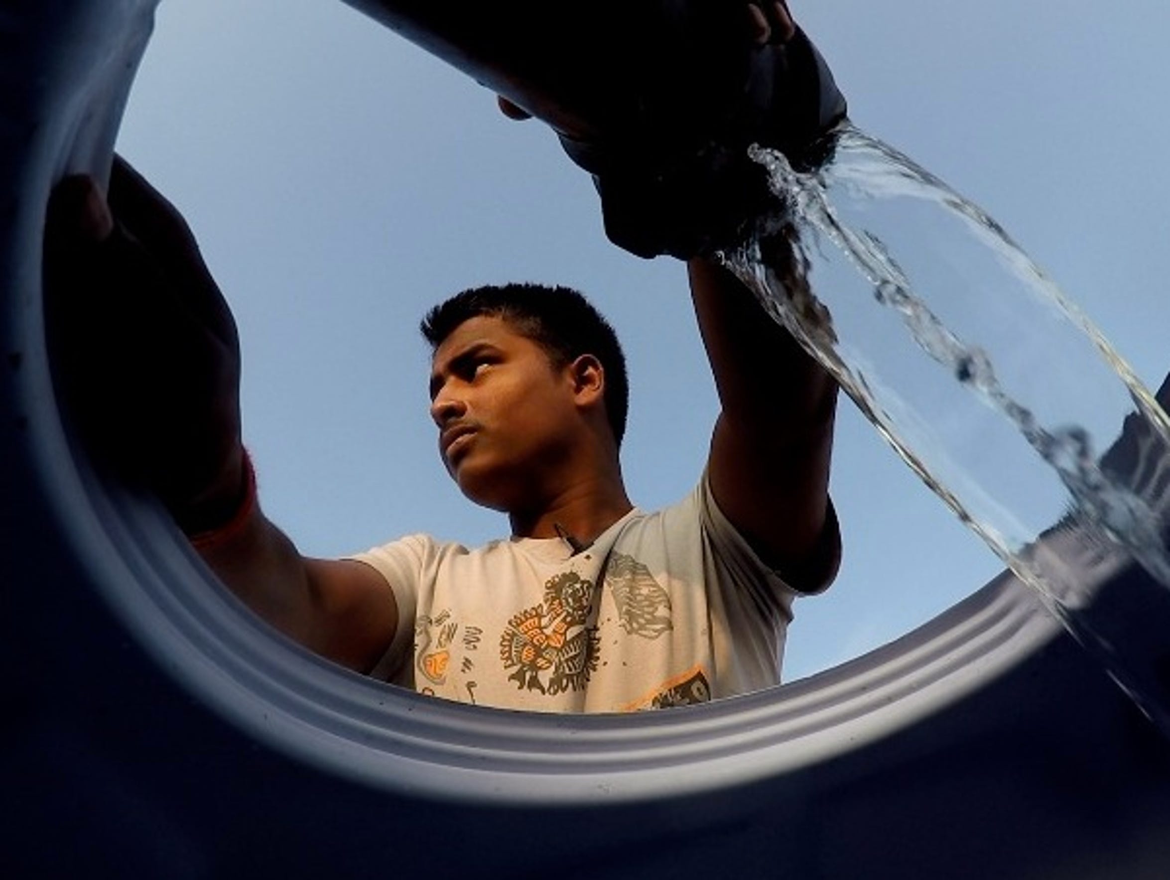 Mukindra Suryawanshi, 22, fills his family's water