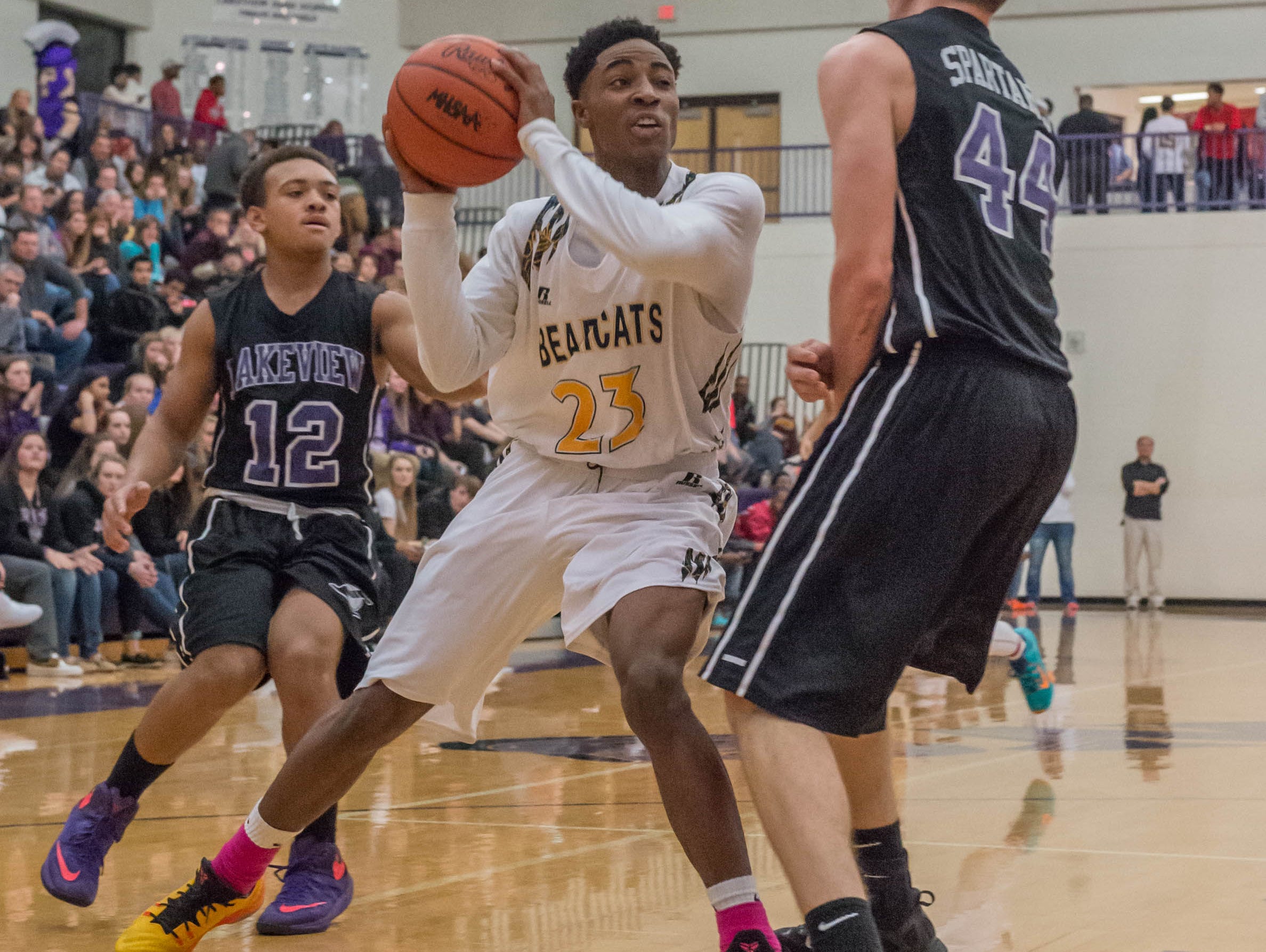 Battle Creek Central's Dontell Hardy (23) goes for the hoop while Lakeview's CJ Foster (12) and Jared Fisk (44) defend during Friday evening's game.