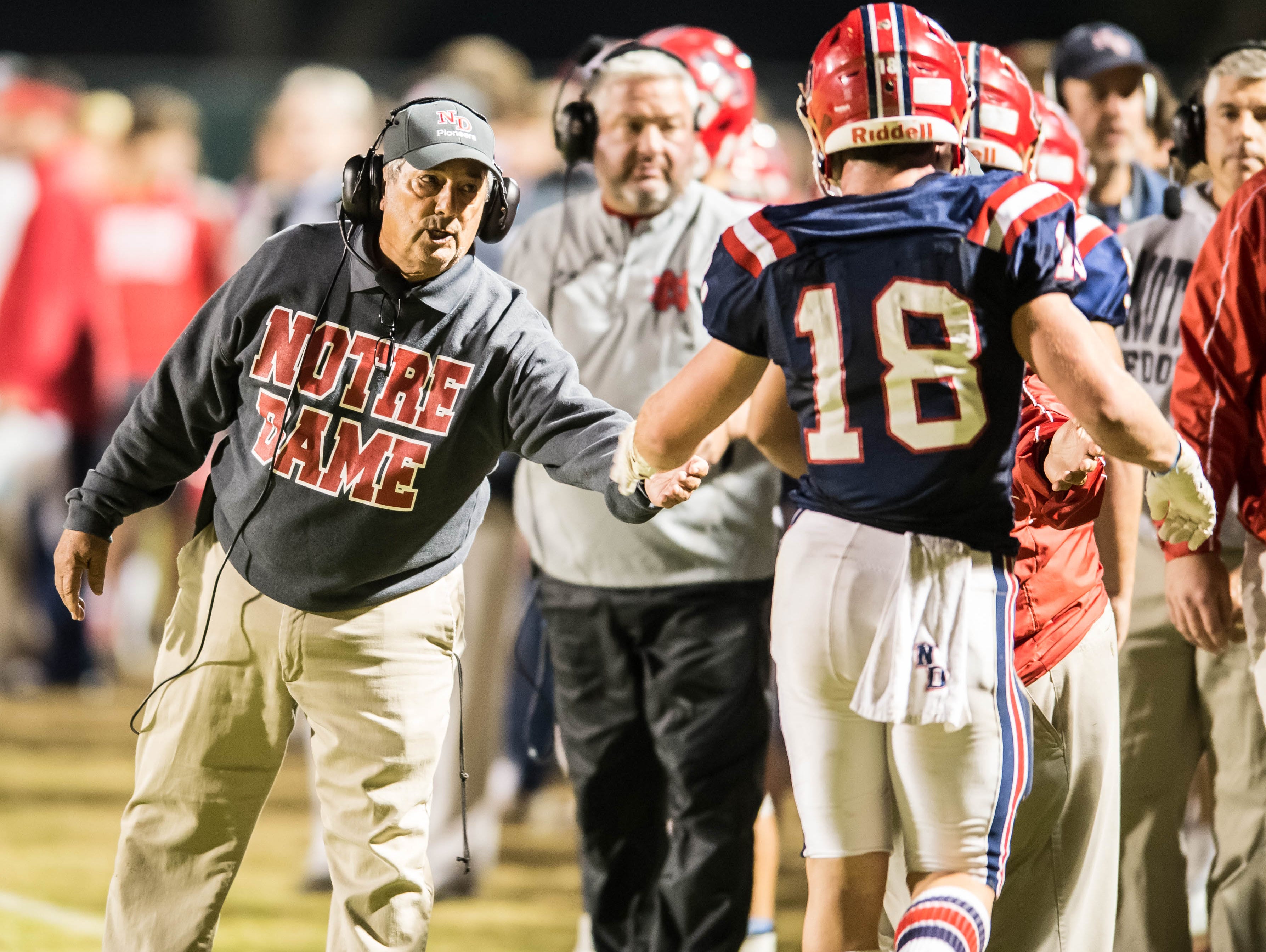 Notre Dame head coach Lewis Cook congratulates Hayden Bourgeois (18) after he scores another Pios touchdown as Notre Dame goes on to defeat Calvary Baptist by a score of 28-7 in the LHSAA Division III quarter finals playoff game in Crowley La. at Gardiner Memorial Stadium on Friday night Nov. 20, 2015.