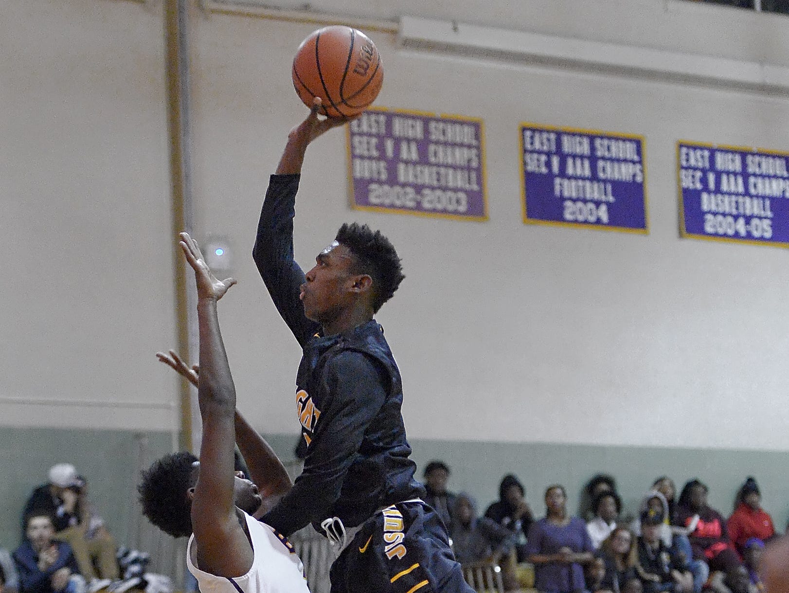 McQuaid's Thomas Jones, right, shoots over East's Darrell Barley on Jan. 5, 2016.