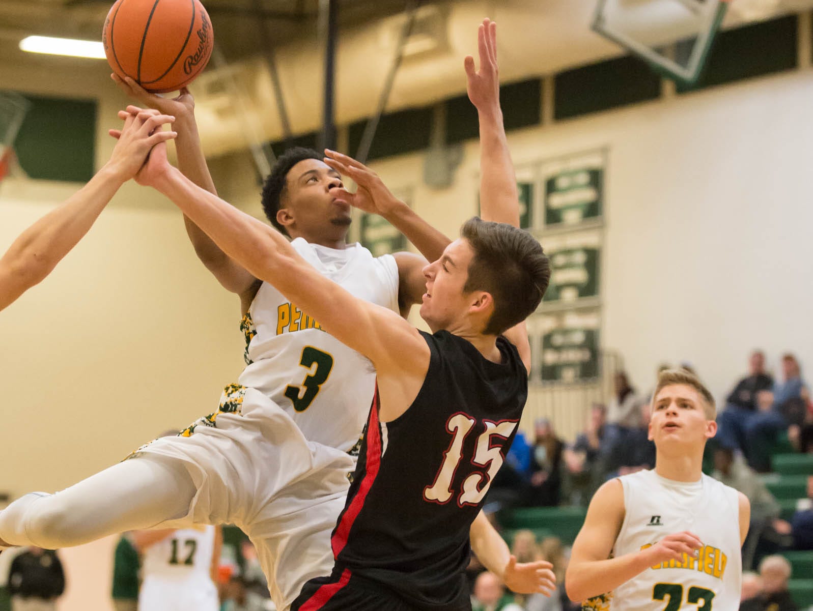 Pennfield's Ronald Jamierson (3) goes for the hoop as Marshall's T. J. Rooco (15) defends during Friday night's game.