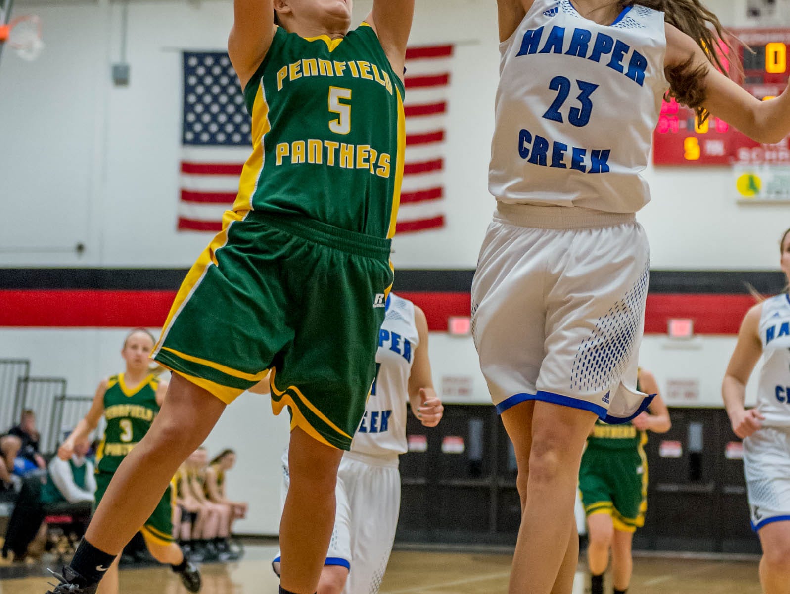 Harper Creek's Charley Andrews (23) goes for the block over Pennfield's Jessica Roan (5) in first round of districts game at Marshall Monday evening.