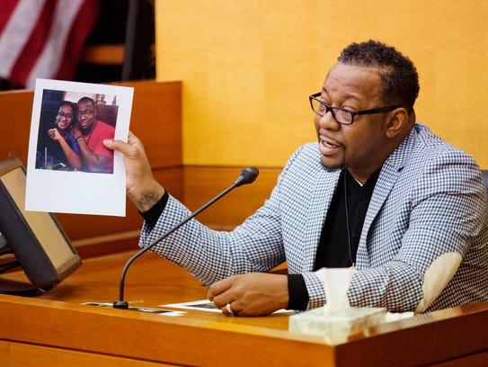 Bobby Brown holds up a picture of his daughter, Bobbi
