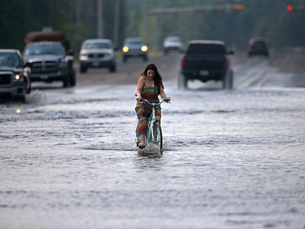 Cara Crawford, turns around after trying to ride her bike through high water to get to Sunday services at a nearby church, in the aftermath of Tropical Storm Harvey in Vidor, Texas on Sept. 3, 2017.