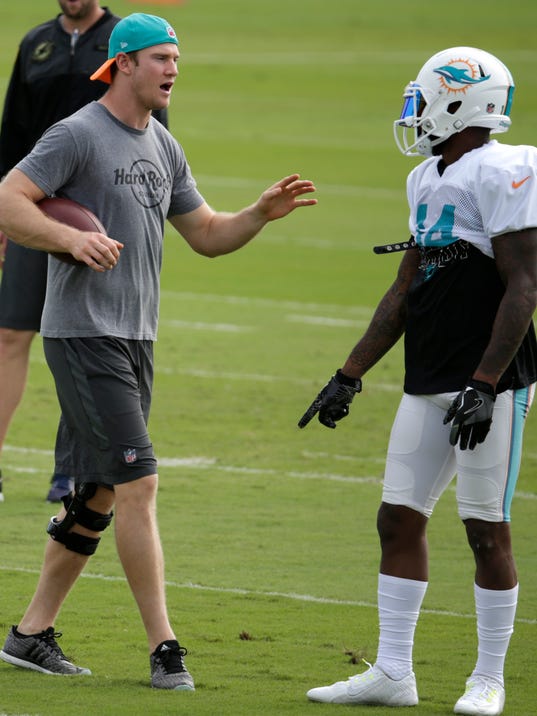 Miami Dolphins quarterback Ryan Tannehill, left, talks with wide receiver Jarvis Landry (14) during NFL football practice, Wednesday, Jan. 4, 2017 in Davie, Fla. Tannehill didn't take part in practice, making it unlikely he'll return from a left knee injury. The Dolphins play the Pittsburgh Steelers in an AFC Wild-Card game Sunday. (AP Photo/Lynne Sladky)