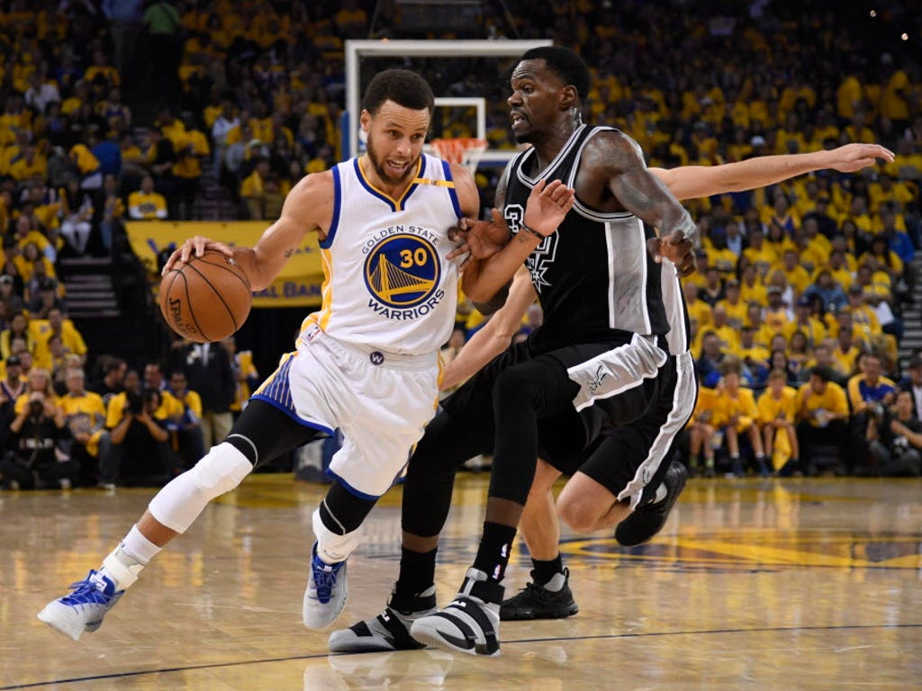 Golden State Warriors guard Stephen Curry (30) dribbles the basketball against San Antonio Spurs center Dewayne Dedmon (3) during the first quarter in Game 2 of the Western Conference finals at Oracle Arena in Oakland.