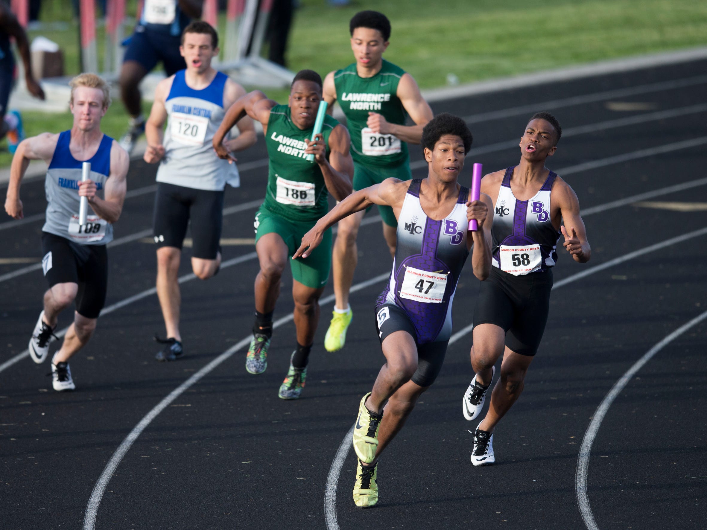 Christian Powell (47), of the Ben Davis High School team, heads out on the final leg after taking a handoff from Rodney Williams, during their winning 4 X 100 meter effort, boys marion county track meet, Indianapolis, Wednesday, May 13, 2015.