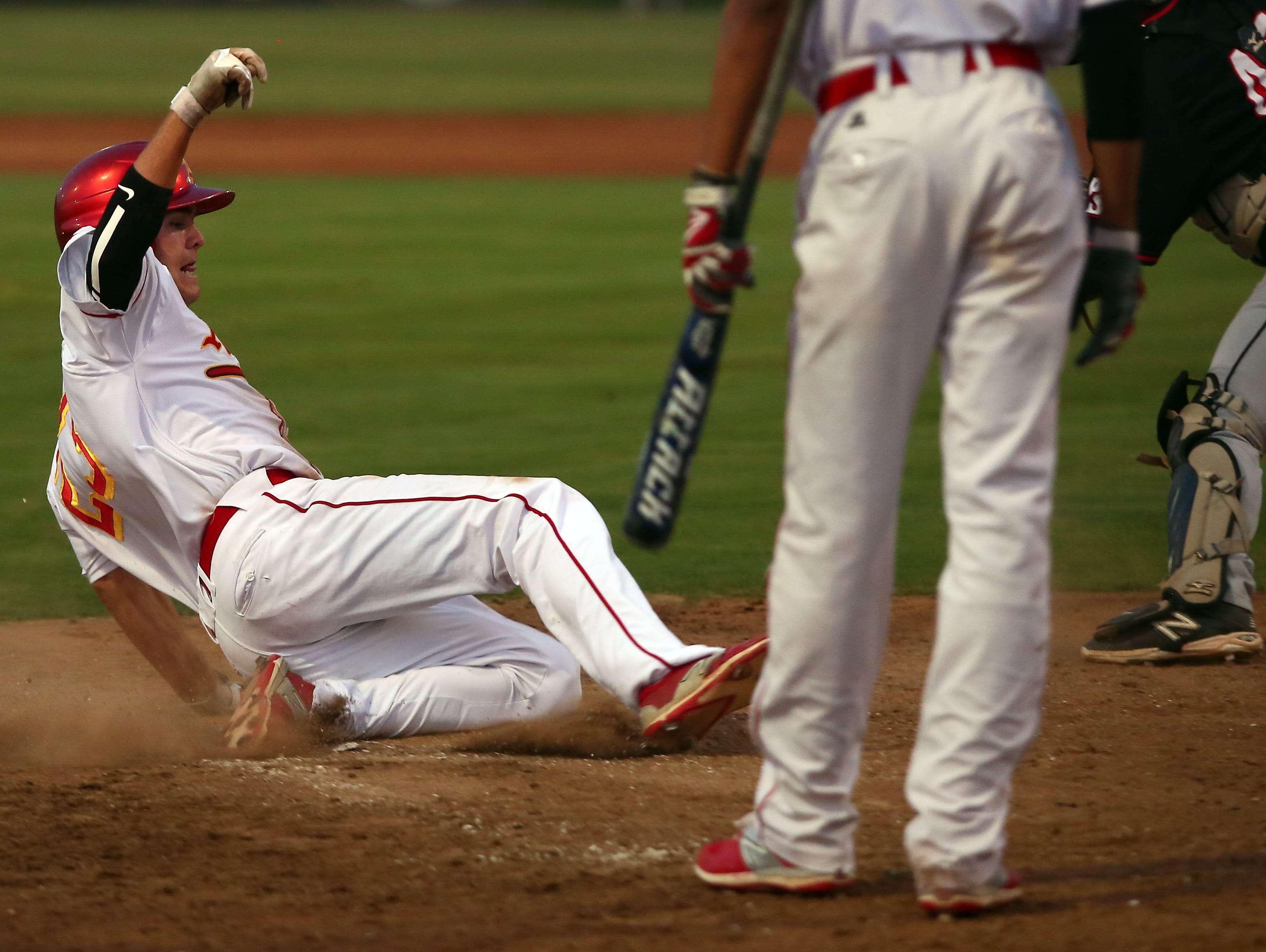 Palm Desert's Beau Berryhill (23) slides across home plate to score as the Aztecs host the Palm Springs Indians at home Tuesday, April 5, 2016.