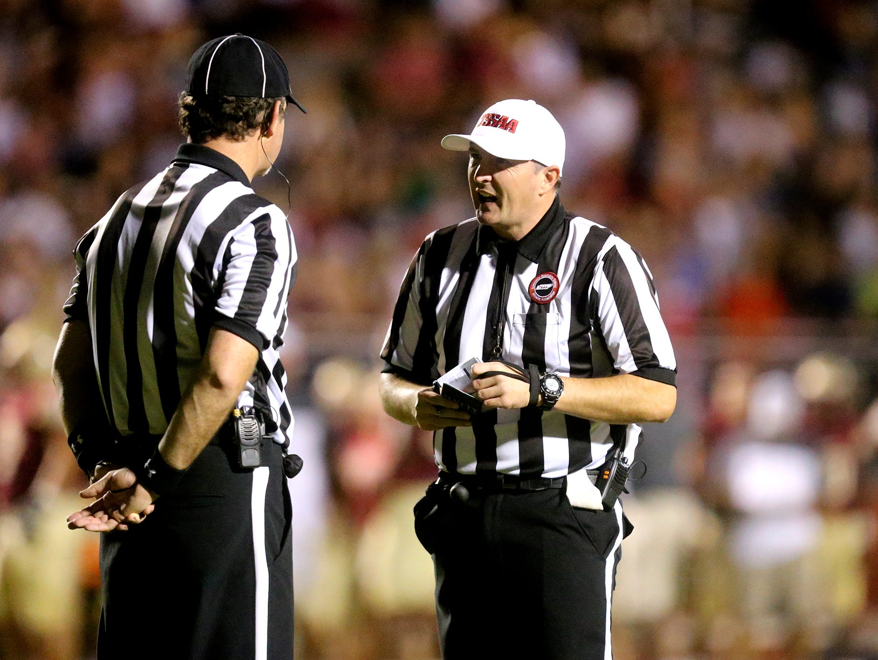 Referees Peter Keating, left and Jeremy Tollison talk during a break in the action of the Riverdale football game against Blackman on Sept. 2, 2016.