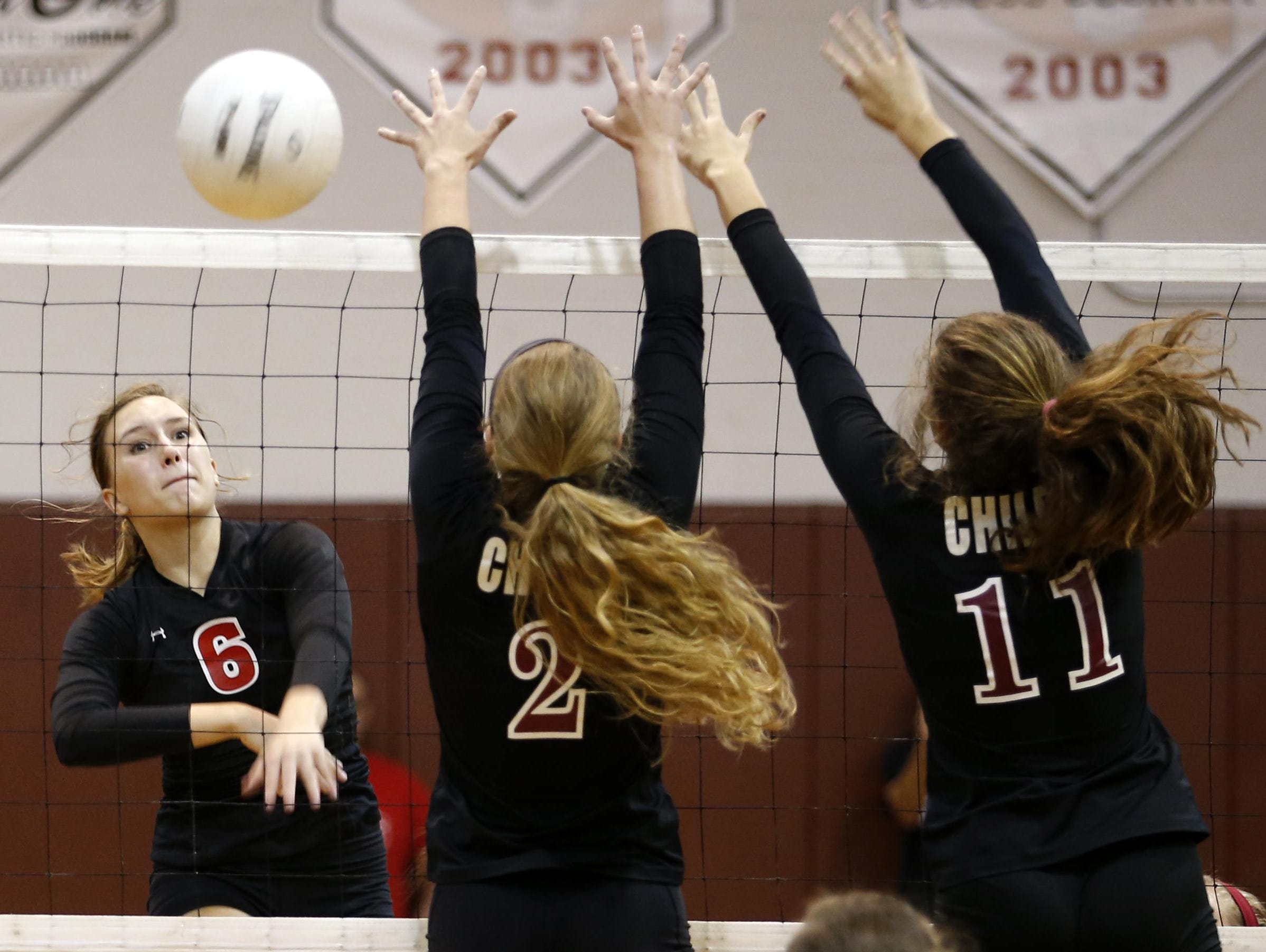Leon's Grace Pickron spikes the ball past Chiles' Lauren Rizza, left, and Katie Parmalee during their match at Chiles High School on Thursday.