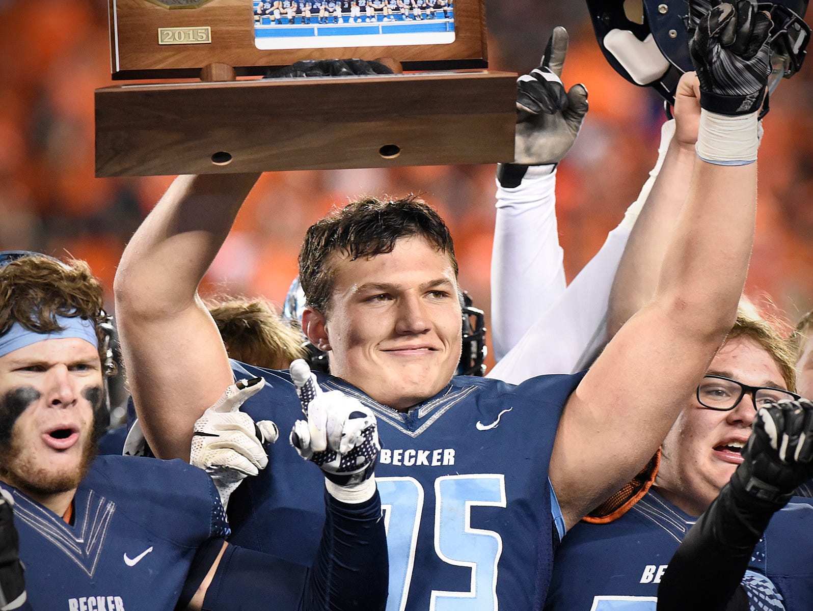 Becker's Dillon Radunz holds the trophy as players celebrate their state title after beating South St. Paul in the Nov. 13 Class 4A state title game at TCF Bank Stadium in Minneapolis.