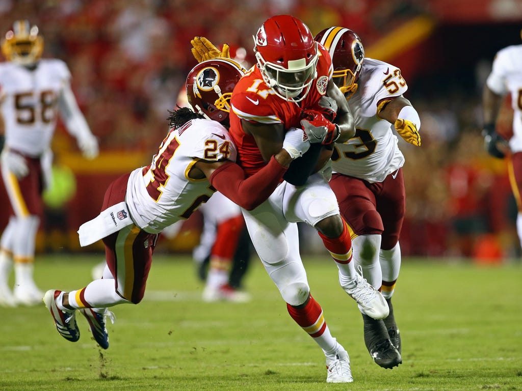 Kansas City Chiefs wide receiver Chris Conley is tackled by Washington Redskins cornerback Josh Norman, left, and linebacker Zach Brown, right, in the first half at Arrowhead Stadium in Kansas City, Mo.