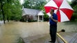 Neighbor Buford Eubanks looks at a flooded house at