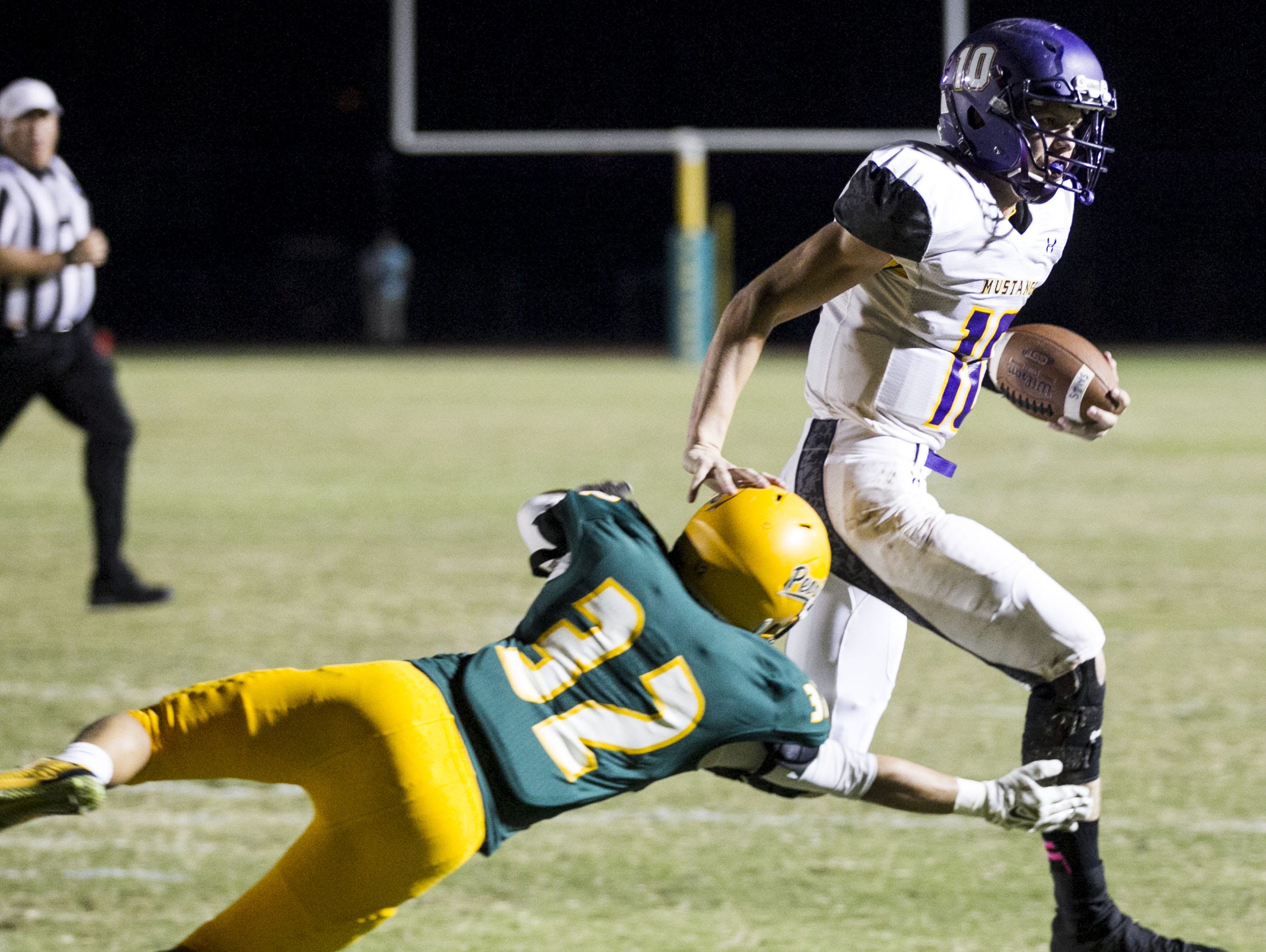 Peoria Sunrise Mountain quarterback Chase Cord (right) runs the ball into the end zone in the second quarter of their victory against Peoria on Friday Oct. 24, 2014.