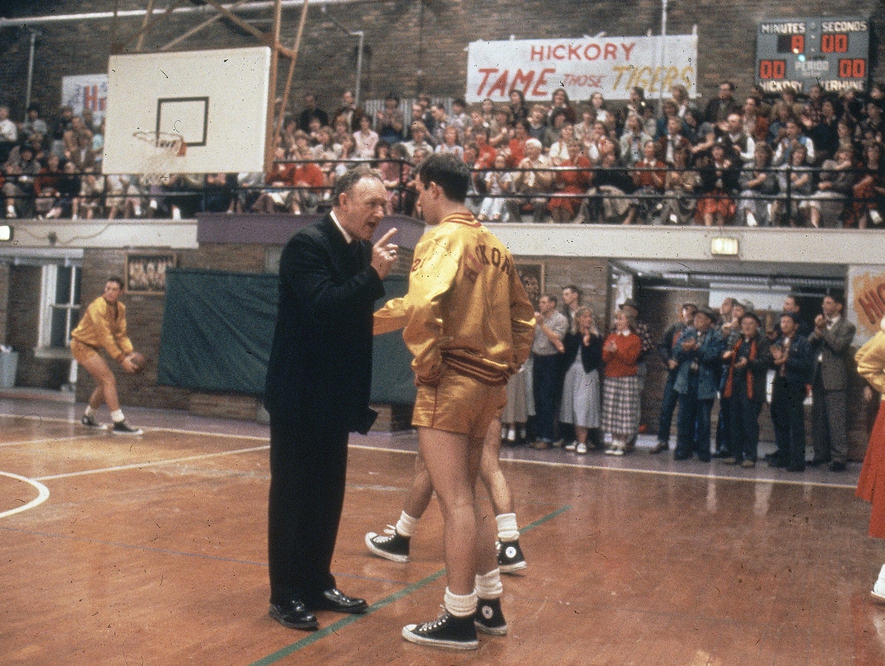 Actor Gene Hackman (left), as coach Norman Dale, talks to a player on the court in the 1986 movie "Hoosiers."