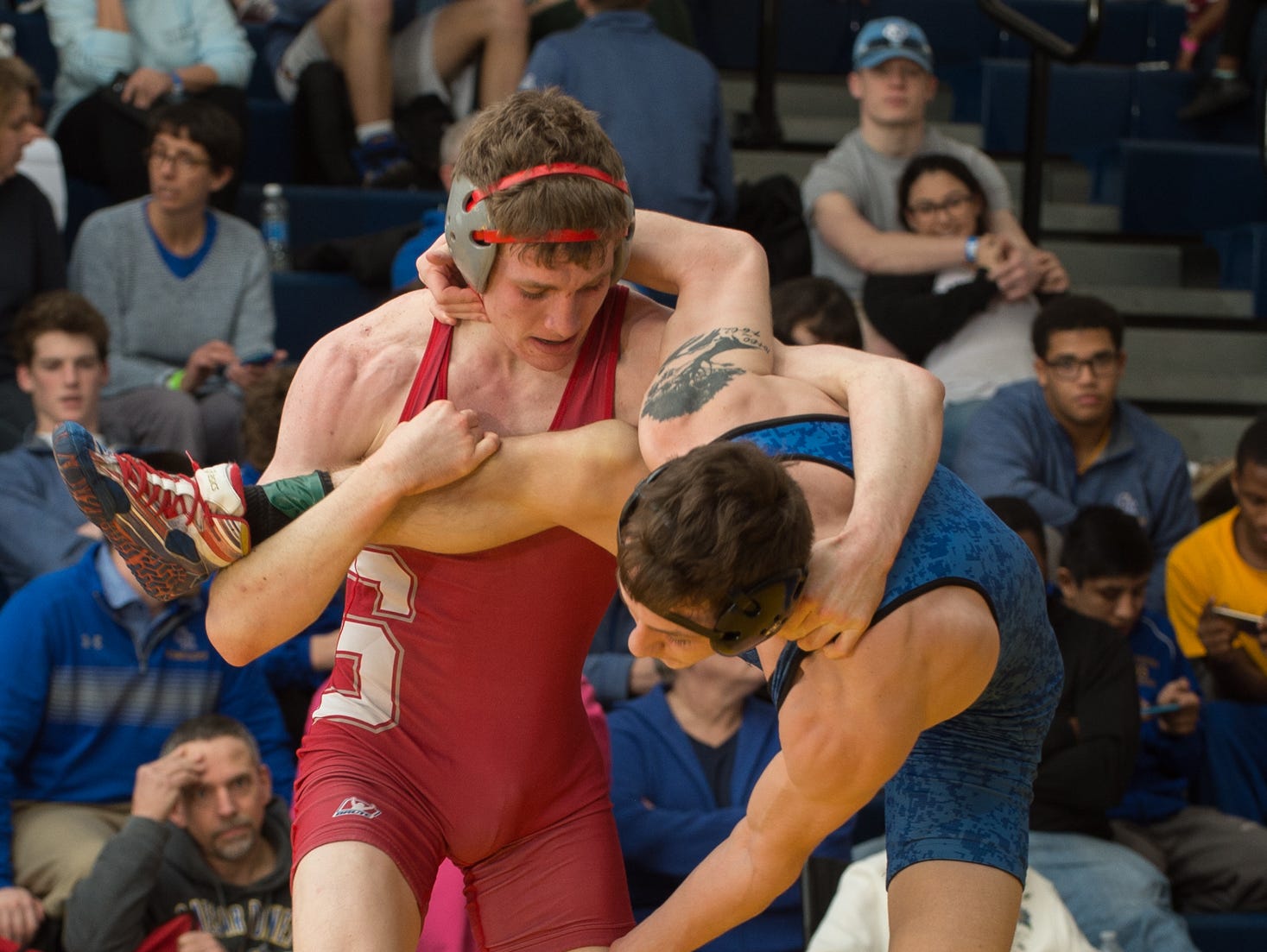 Smyrna's Chase Archangelo holds the leg of Dover's Nicholas Lee in the 145 pound championship match at the Henlopen Conference wrestling tournament at Sussex Central High School.