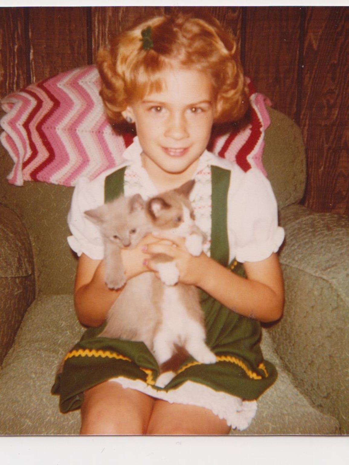 Heidi Wolfe poses for a picture with two kittens. Year