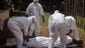 Health workers carry the body on Oct. 20, of a woman