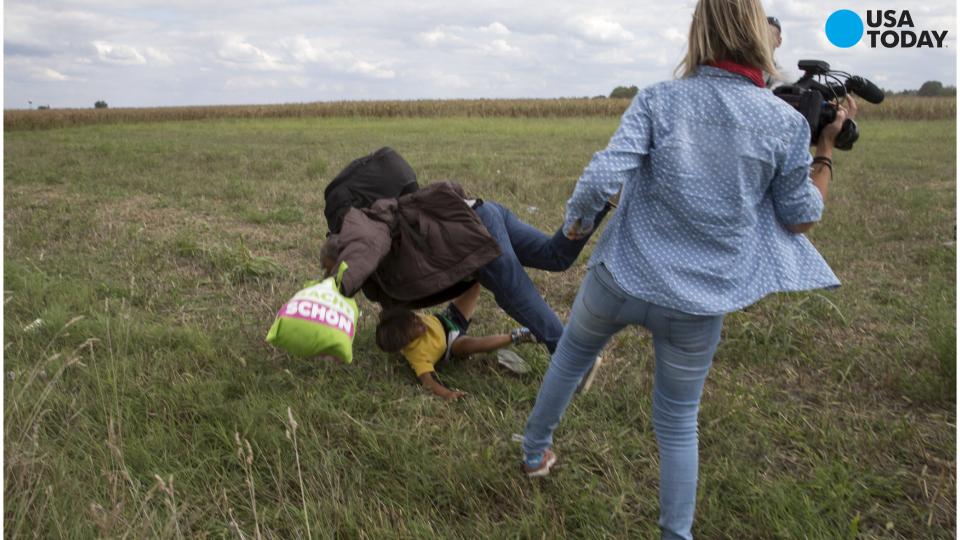 Hungarian journalist filmed tripping man carrying migrant child