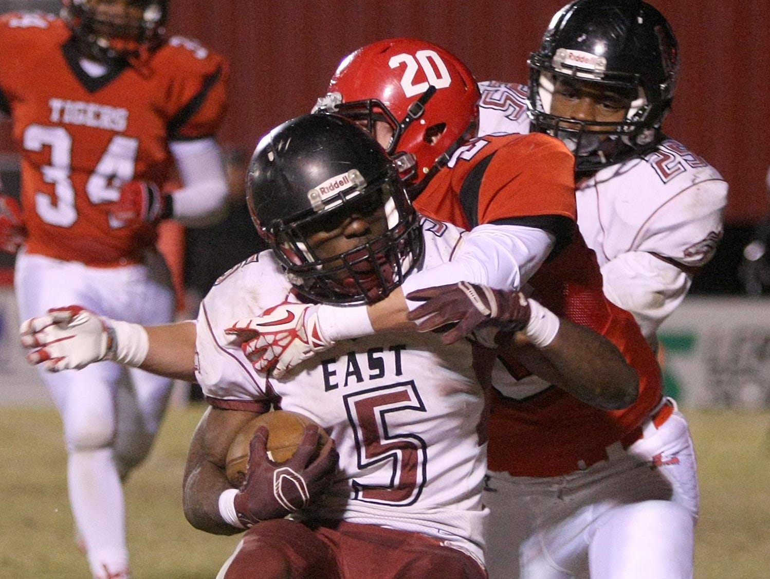 Lexington's Trip Sullivan (20) tackles Memphis East's Devante Turner (5) at Tiger Stadium on Friday.