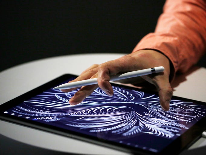 A man uses the new Apple Pencil on an iPad Pro after