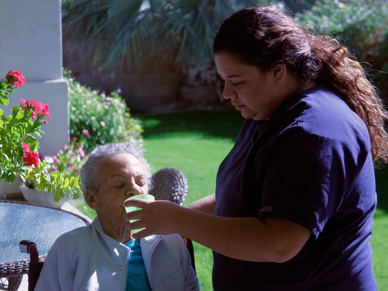 Bianca Colorado, a caregiver at Desert Cottages, gives