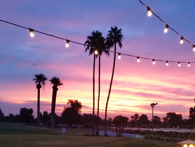 The rising sun will soon overpower the strings of lights