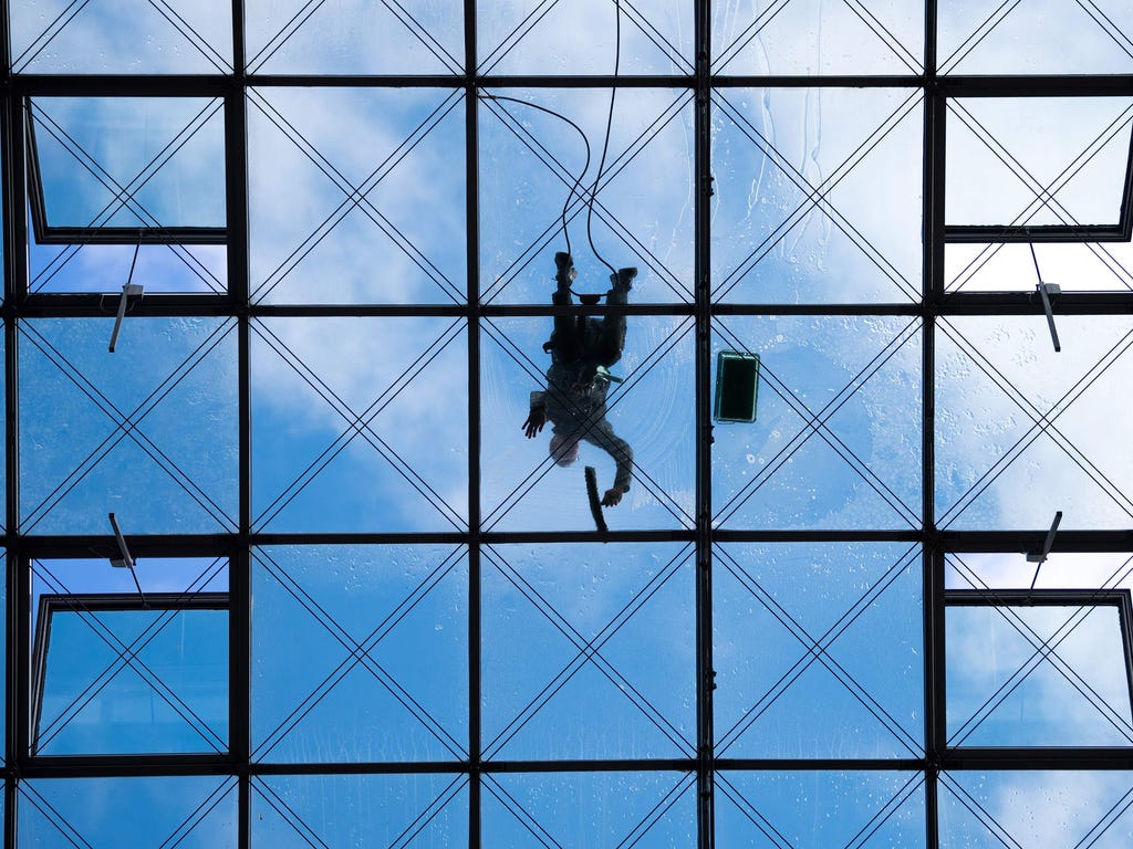 A window washer cleans the glass roof of the World Trade Center (WTC) hotel and office building in Dresden.